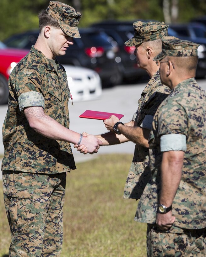 MARINE CORPS BASE CAMP LEJEUNE, N.C. – Maj. Gen. Carl E. Mundy III, U.S. Marine Corps Forces, Special Operations Command commander, awards the Bronze Star Medal with Combat “V” to Staff Sgt. Patrick H. Maloney, multi-purpose canine handler with 2D Marine Raider Battalion, at Camp Lejeune, N.C., Oct. 30, 2017. While deployed in support of Operation Inherent Resolve in August 2016, Maloney exposed himself to enemy fire to employ a heavy machinegun mounted in an open truck bed during an enemy ambush. Despite two weapon malfunctions, Maloney effectively suppressed and disrupted the ambush, allowing Raiders to repel the attackers. Maj. Gen. Mundy presented the award on behalf of the President. (U.S. Marine Corps photo by Sgt. Salvador R. Moreno, released)