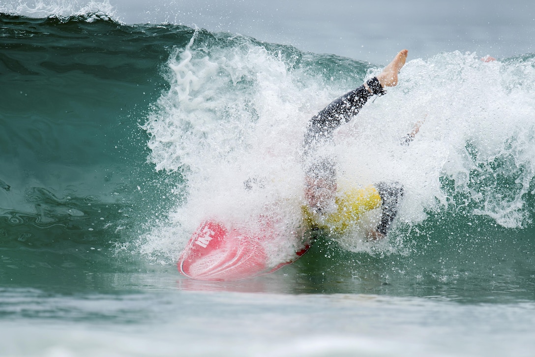 A surfer wipes out while surfing.