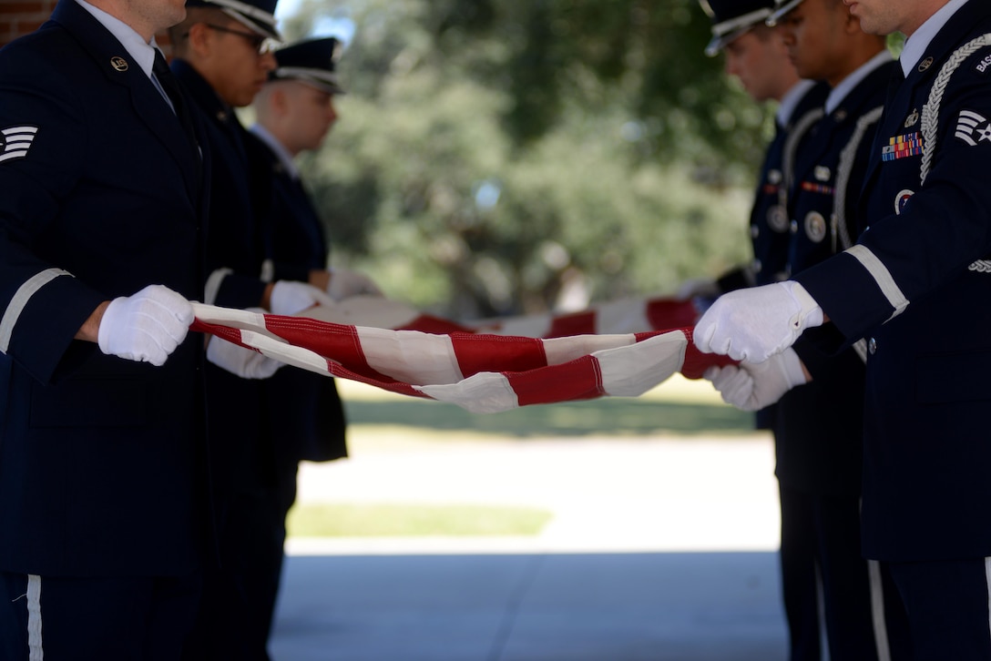 Keesler Air Force Base Honor Guard members practice flag folding procedures before a funeral ceremony Oct. 26, 2017, at the Biloxi National Cemetery in Biloxi, Mississippi. Before every funeral detail, honor guardsmen arrive an hour early to practice their roles to ensure each move is precise. (U.S. Air Force photo by Airman 1st Class Suzanna Plotnikov)
