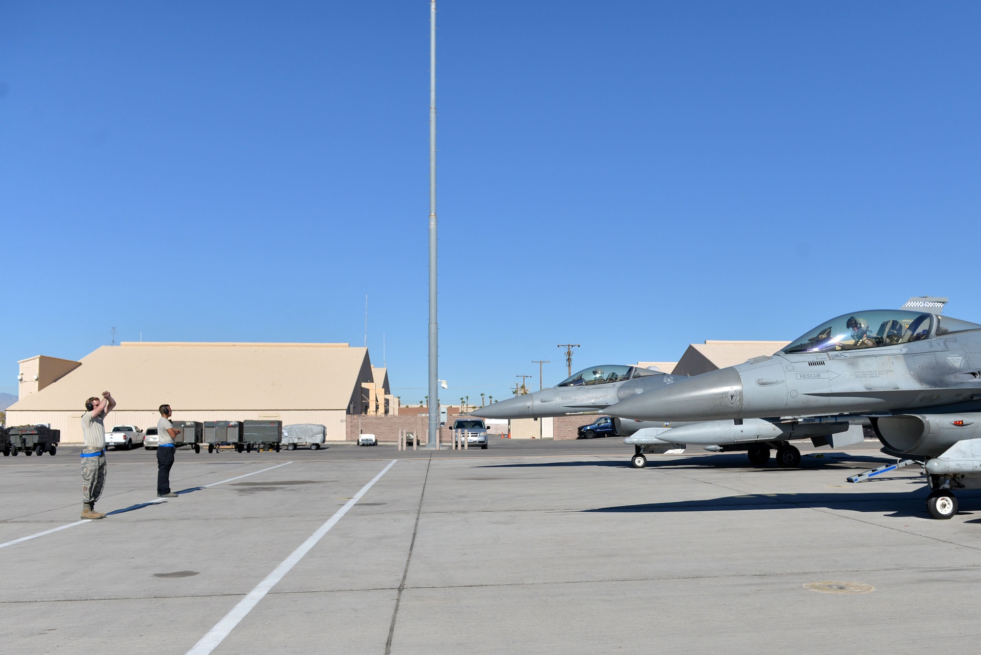 Tactical aircraft maintainers prepare to marshal out F-16CM Fighting Falcons at Nellis Air Force Base (AFB), Nevada, Oct. 10, 2017.