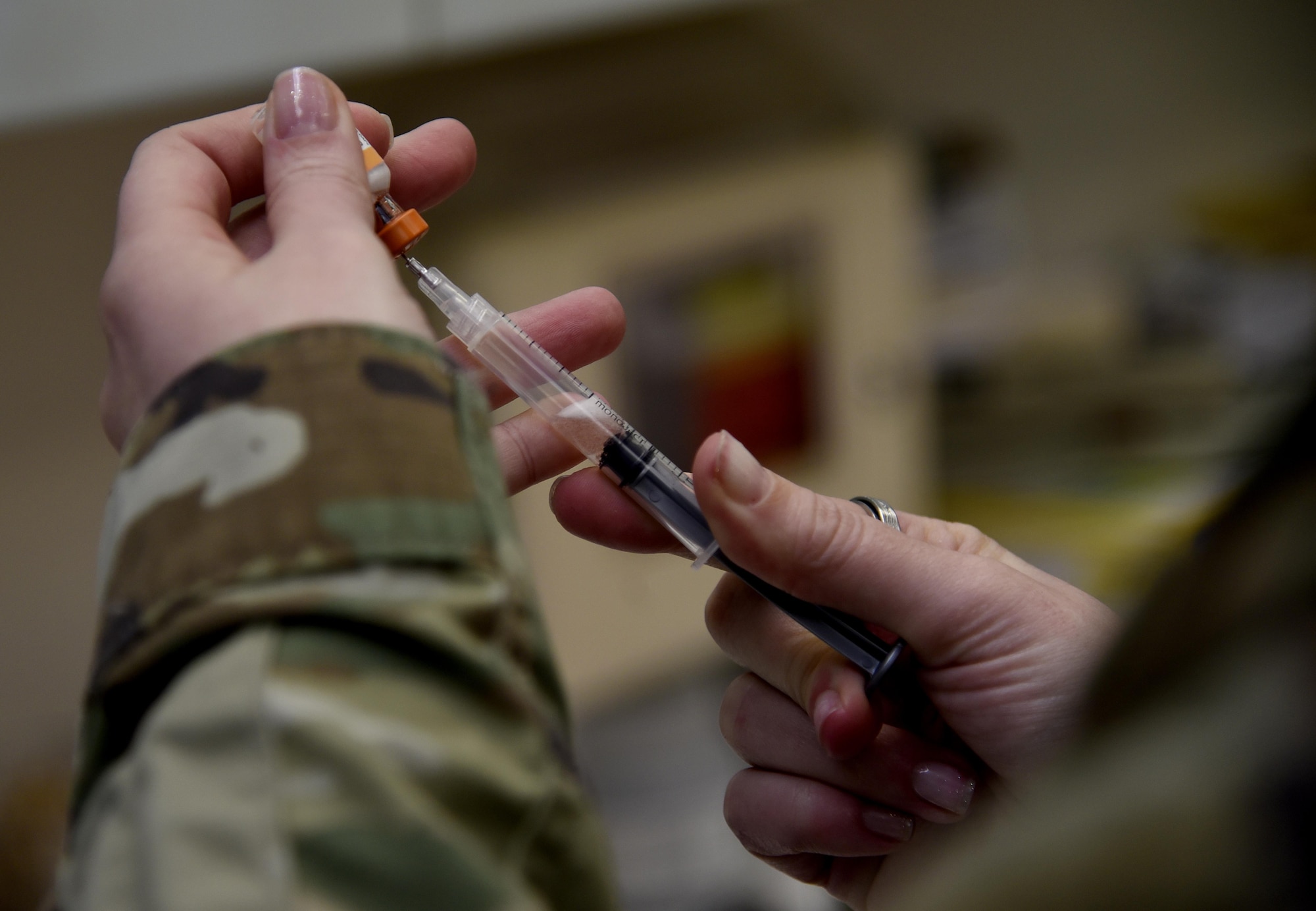 A vet fills a syringe