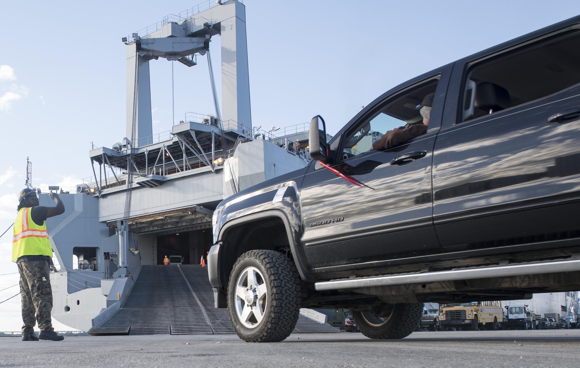 A longshoreman directs a truck moving cargo onto the USNS Brittin (T-AKR-305) Oct. 28, 2017, at Joint Base Charleston’s Naval Weapons Station, S.C.