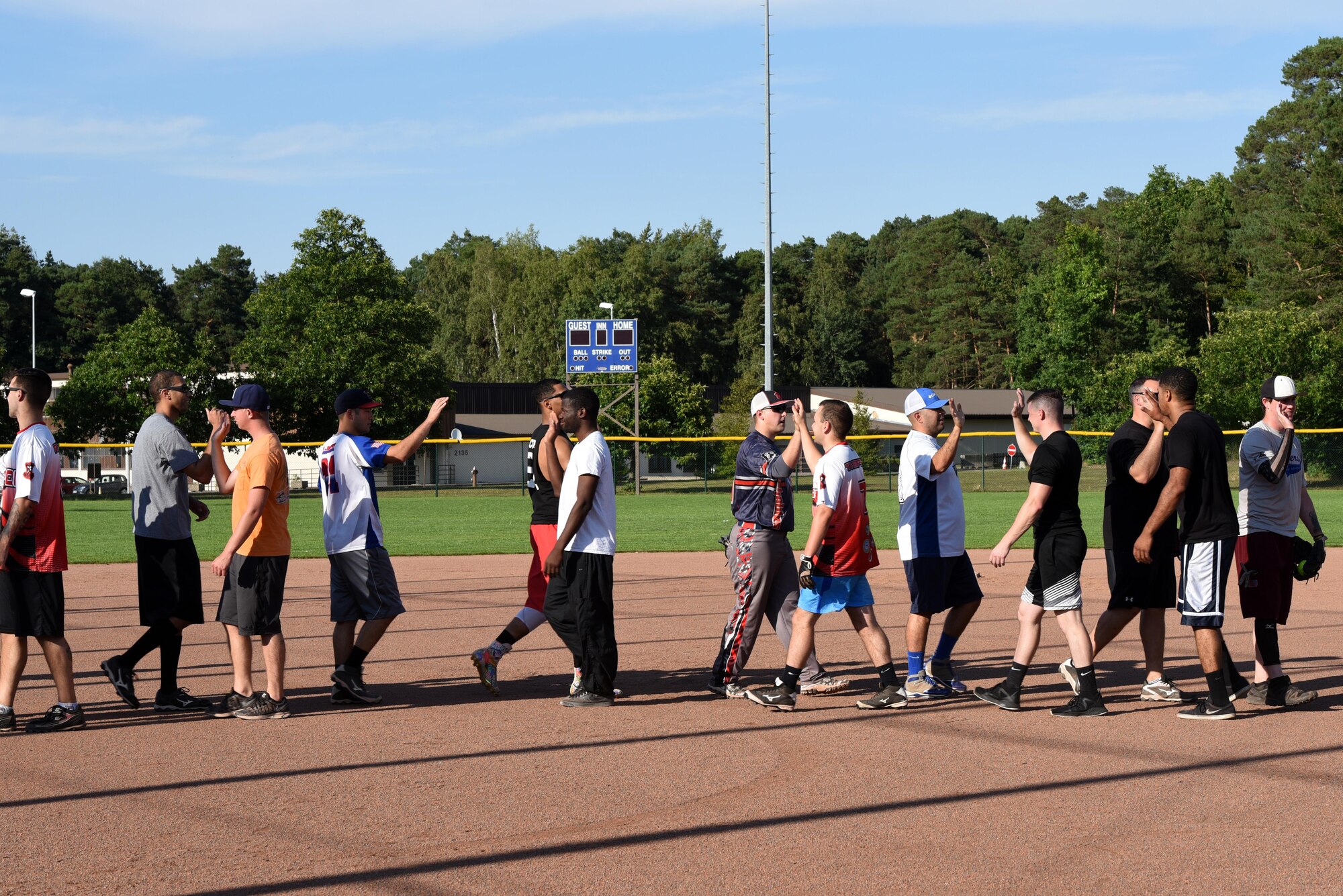 Players from opposing teams high-five one another to show good sportsmanship at the end of an intramural softball game Aug 22, 2017, on Ramstein Air Base, Germany. Professionalism and sportsmanship are two key factors of the intramural sports system that help to boost morale. (U.S. Air Force photo/Airman 1st Class Milton Jr. Hamilton)