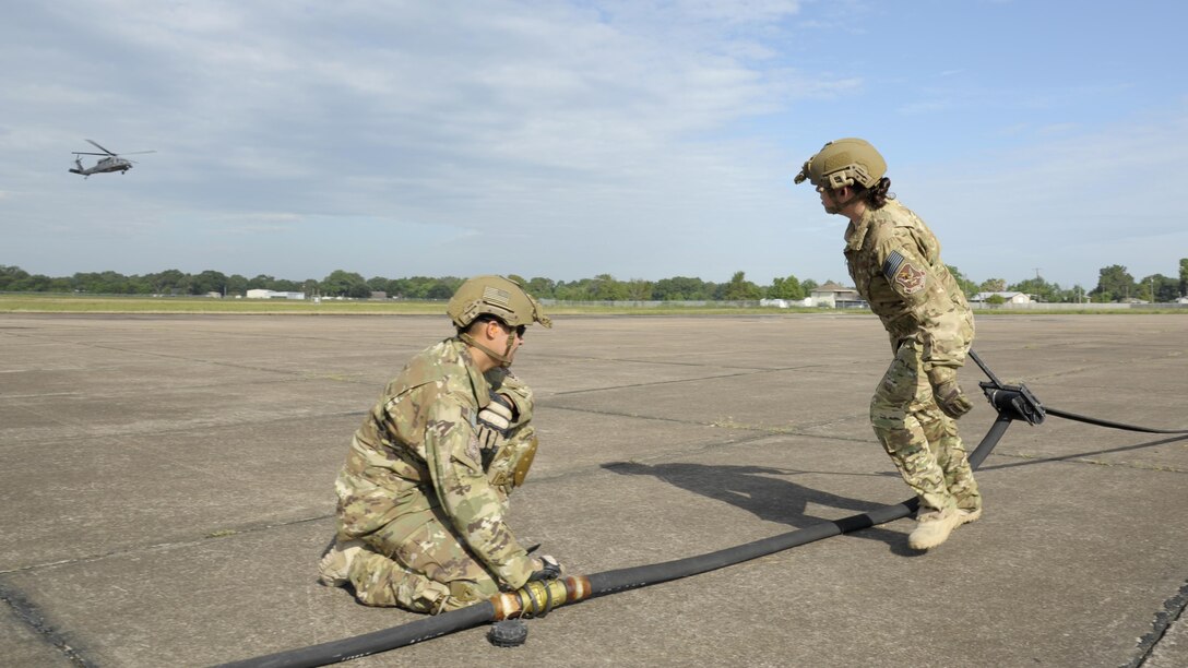 U.S. Air Force Staff Sgt. John San Inocencio, 23d Logistics Readiness Squadron, holds onto a fuel line hose as Tech. Sgt. Shayna Jacoby, 23d Logistics Readiness Squadron, squeegees the hose to remove the remaining fuel following a refuel Aug. 31, 2017, at Jack Brooks Regional Airport in Beaumont, Texas.