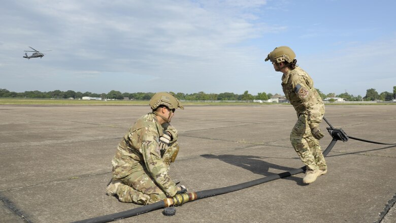 U.S. Air Force Staff Sgt. John San Inocencio, 23d Logistics Readiness Squadron, holds onto a fuel line hose as Tech. Sgt. Shayna Jacoby, 23d Logistics Readiness Squadron, squeegees the hose to remove the remaining fuel following a refuel Aug. 31, 2017, at Jack Brooks Regional Airport in Beaumont, Texas.