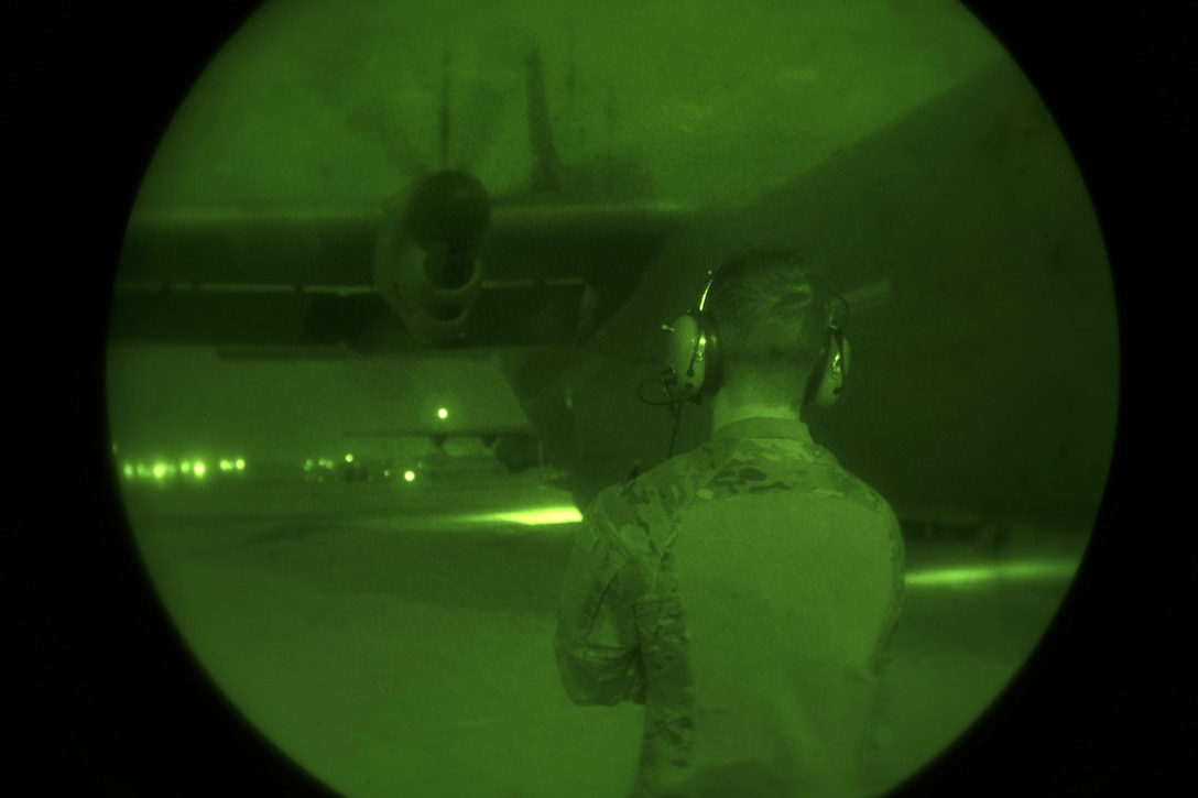 As seen through a night-vision device, Air Force Senior Airman Tom Saunders inspects the propellers of a C-130J Super Hercules