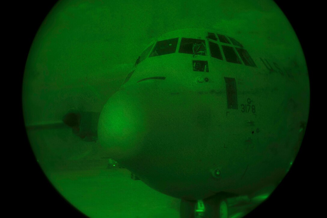 As seen through a night-vision device, a C-130J Super Hercules prepares for takeoff at Bagram Airfield