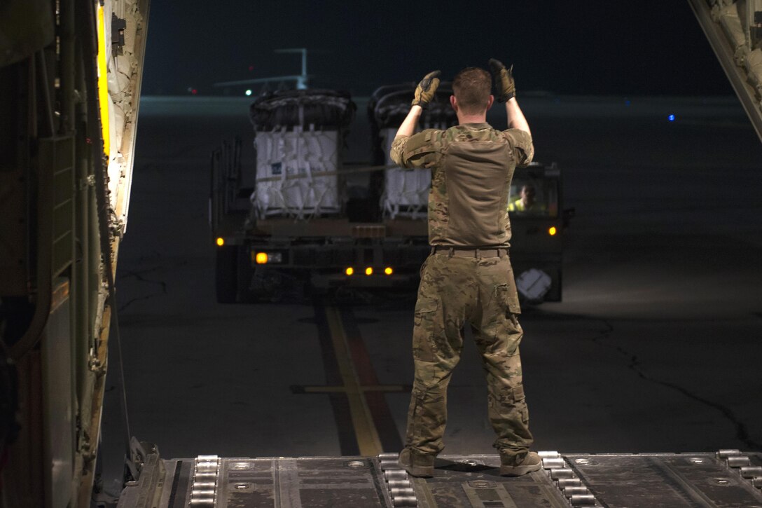 Air Force Senior Airman Tom Saunders directs a k-loader with pallets to be airdropped at Kandahar Airfield