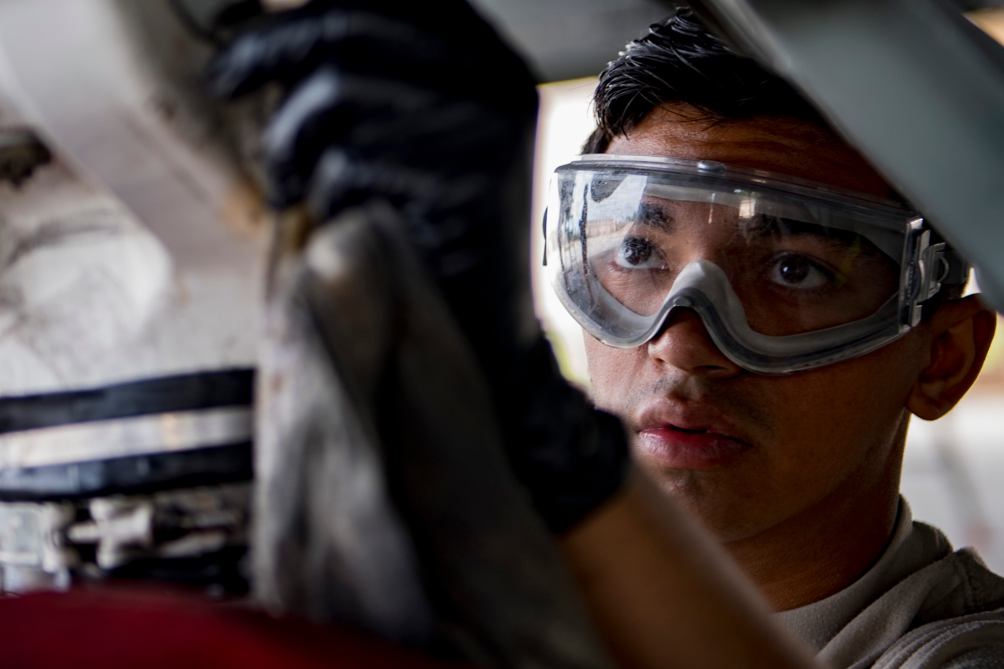 Airman 1st Class Matthew Din, 23d Aircraft Maintenance Squadron 74th Aircraft Maintenance Unit crew chief, wipes away grease before washing an A-10C Thunderbolt II, Aug. 28, 2017, at Moody Air Force Base, Ga. Maintenance procedures require that A-10s are washed at least every 180 days to prevent maintenance issues and safety hazards to the pilot. Since strong chemicals are used to clean the aircraft Airmen must wear personal protective equipment. (U.S. Air Force photo by Airman 1st Class Daniel Snider)