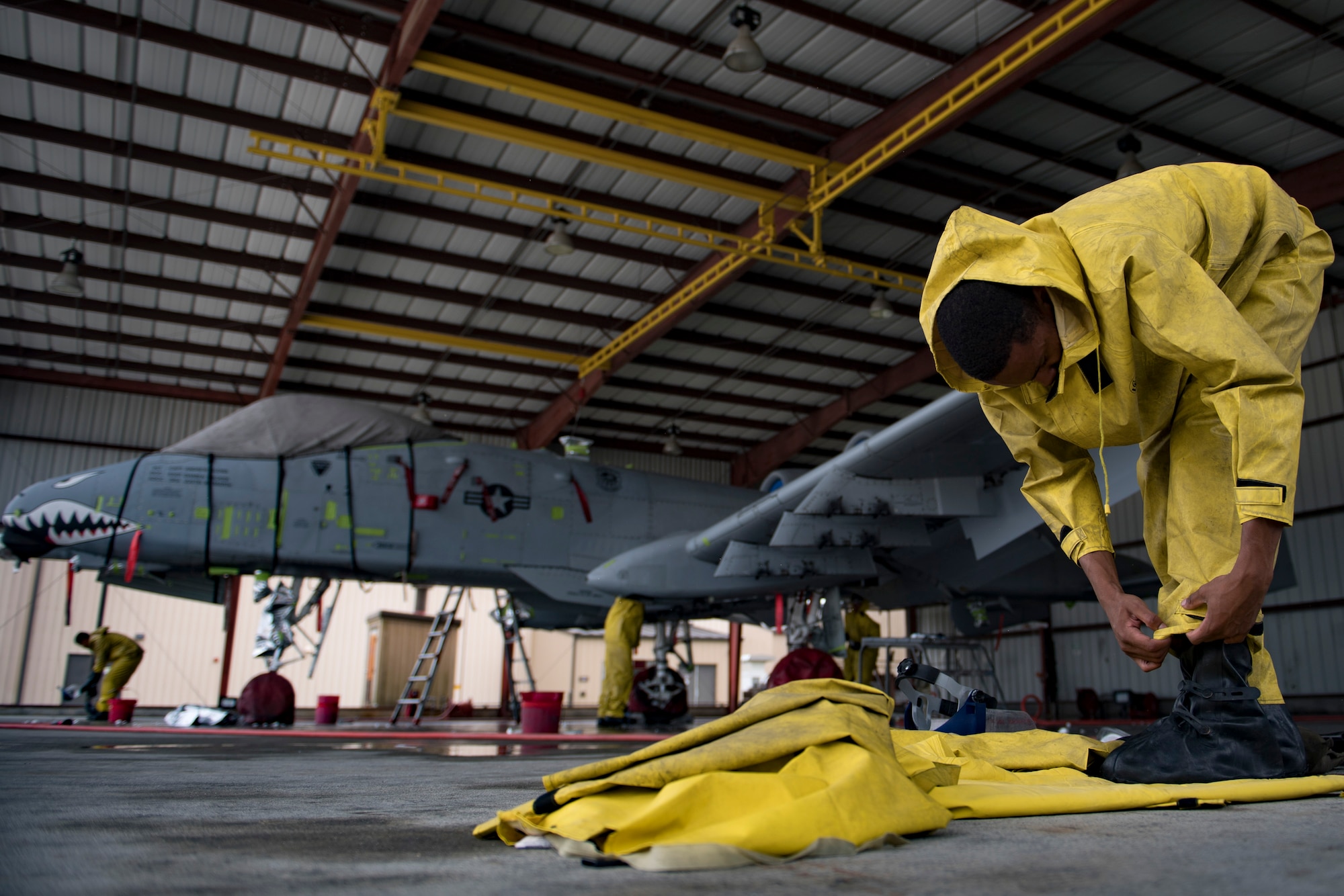 Airman 1st Class Michael Wilson-Jones, 23d Aircraft Maintenance Squadron 75th Aircraft Maintenance Unit electrical and environmental technician, dawns personal protective equipment before washing an A-10C Thunderbolt II, Aug. 28, 2017, at Moody Air Force Base, Ga. Maintenance procedures require that A-10s are washed at least every 180 days to prevent maintenance issues and safety hazards to the pilot. Since strong chemicals are used to clean the aircraft Airmen must wear personal protective equipment. (U.S. Air Force photo by Airman 1st Class Daniel Snider)