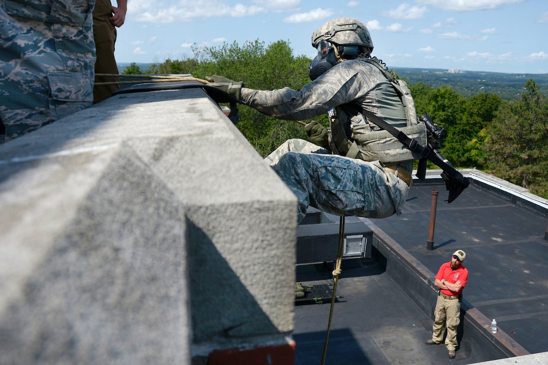 Tech. Sgt. Dedrick Baublitz rappels down the side of an abandoned hospital.