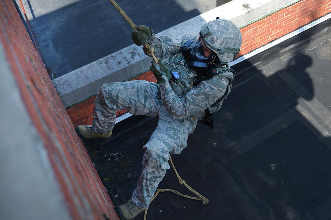 Tech. Sgt. Dedrick Baublitz rappels down the side of an abandoned hospital as part of a training exercise