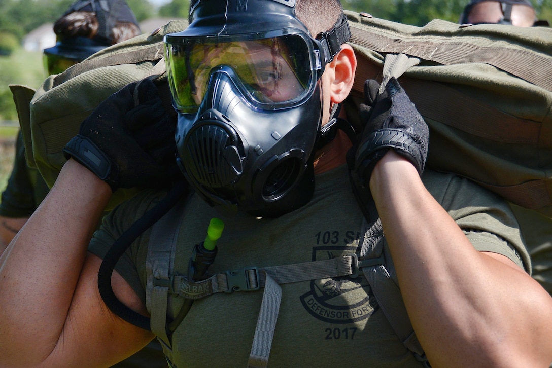 Airman 1st Class Emilio Masella carries a bag of gear through an obstacle course as part of a training exercise