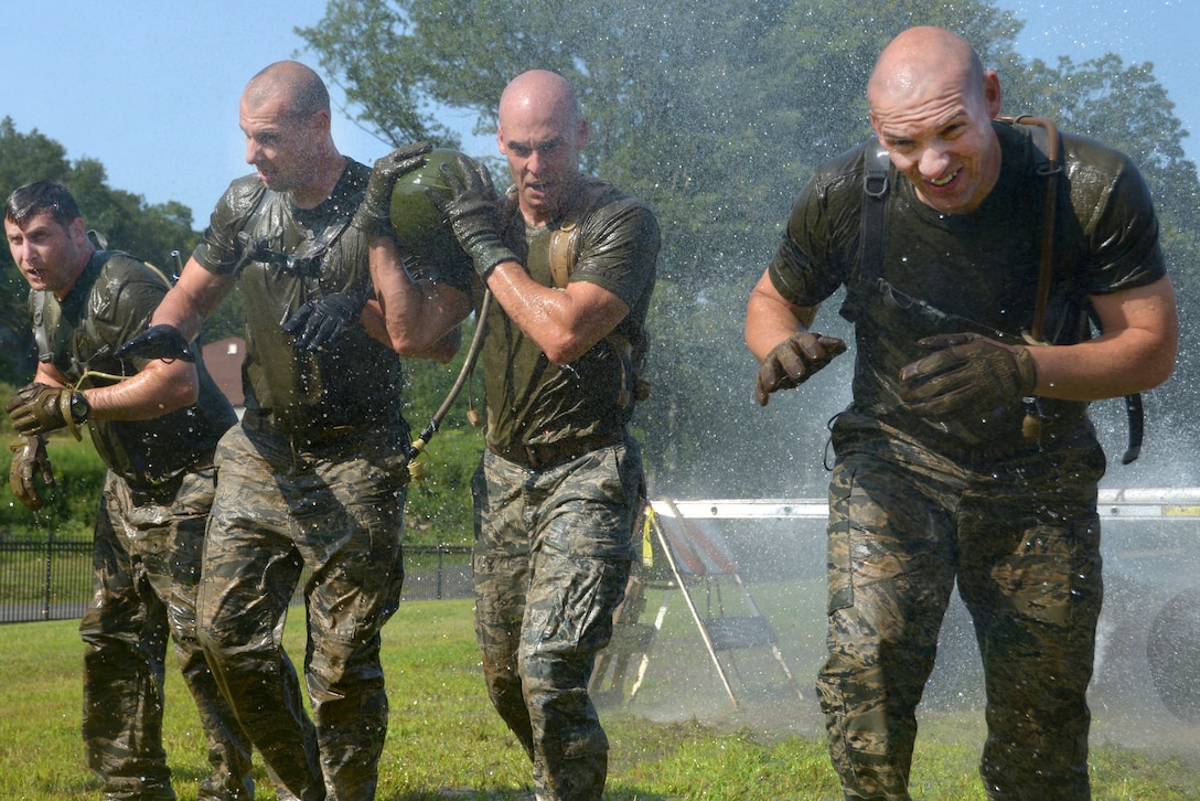 Connecticut Air National Guard team members get sprayed with a fire hose