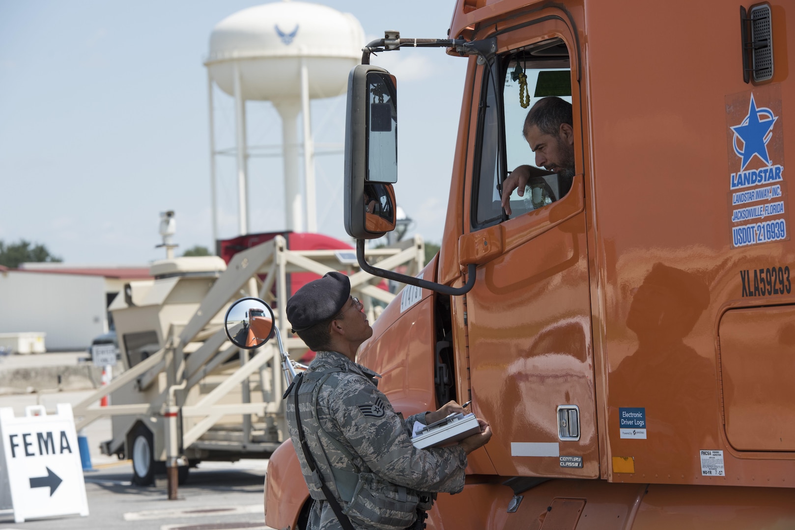 Airman on ground confers with driver of supply truck