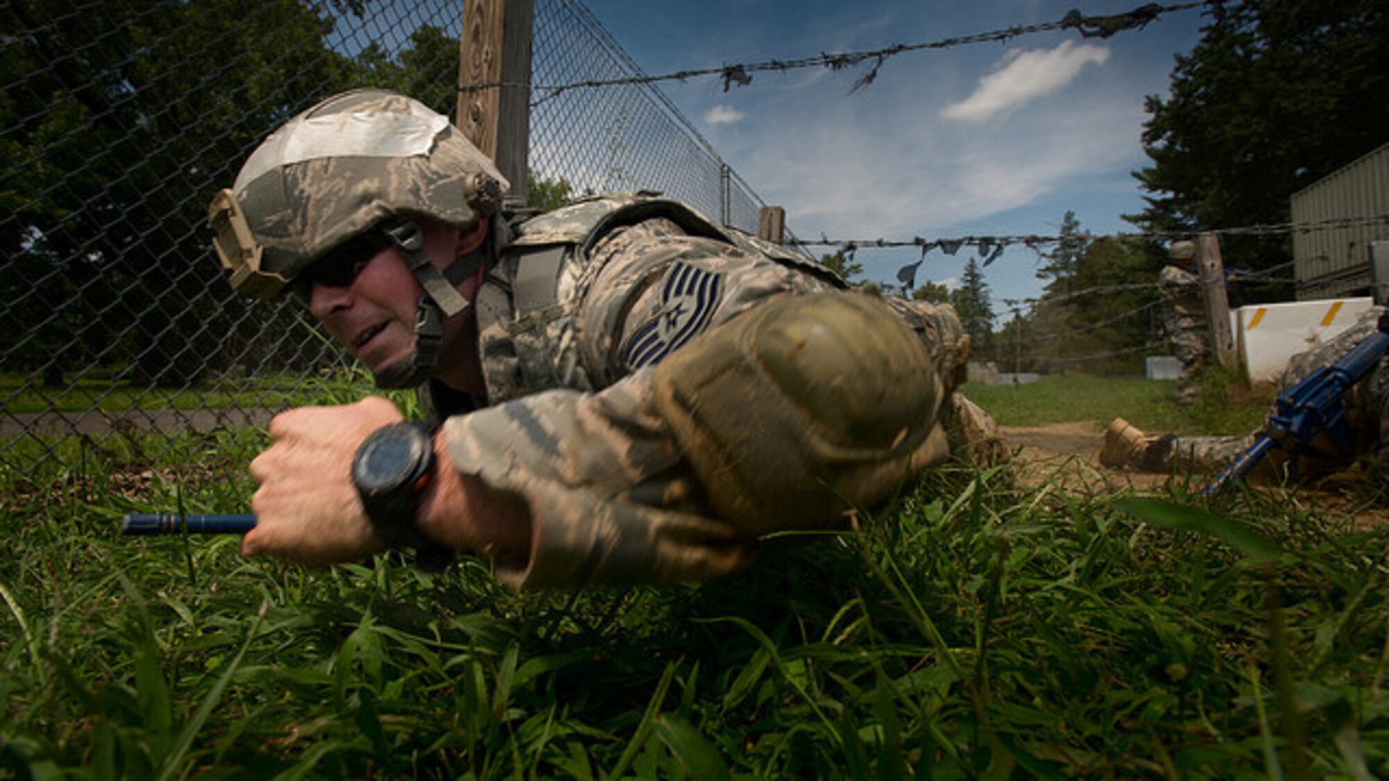 Tech. Sgt. Joshua B. Welter, 621st Contingency Response Squadron aircraft maintenance craftsman, low crawls under barbed wire during a training exercise at the Medical Simulation Training Center at Joint Base McGuire-Dix-Lakehurst, N.J. on Aug. 17, 2017. The MSTC program supports training for medical and non-medical personnel including active duty, reserve, and National Guard service members with a priority given to deploying units. (U.S. Air Force photo by Airman 1st Class Jessica Blair)