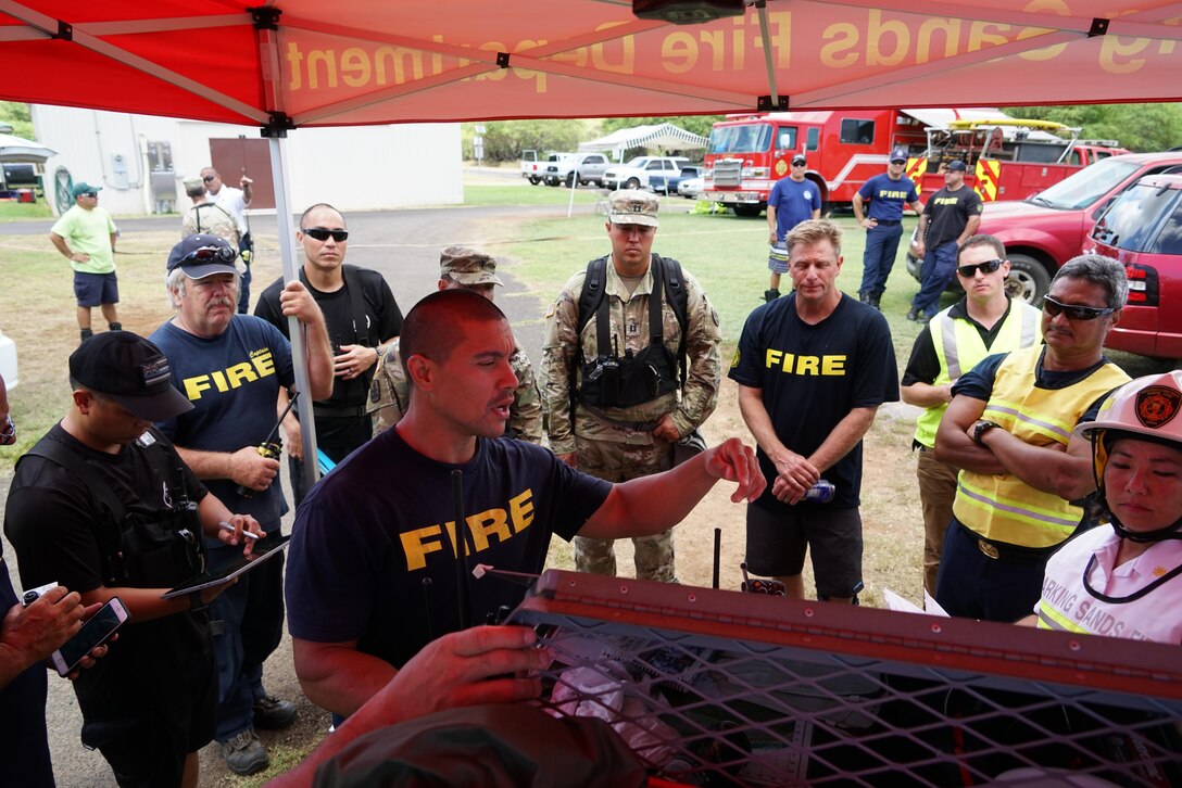 A Kauai County firefighter briefs first responders on the simulated hazmat conditions found during Kauai County Exercise 2017 at the Pacific Missile Range Facility in Kauai, Hawaii, Aug. 30, 2017. Hawaii Air National Guard photo by Tech. Sgt. Andrew Jackson