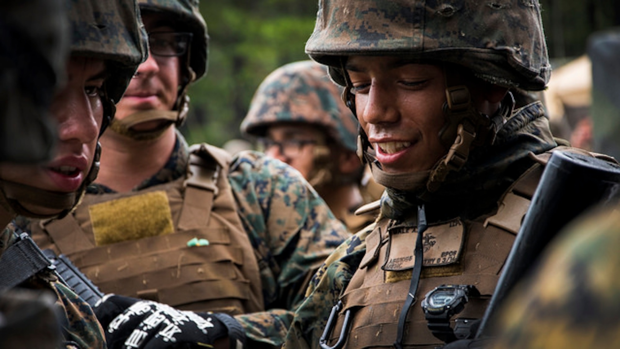 Lance Cpl. Azael O. Gale, Battery G, 3rd Battalion, 14th Marines cannoneer, smiles while standing in line for lunch during artillery training at Joint Base McGuire-Dix-Lakehurst, N.J. on Aug. 18, 2017. The live fire training prepares the team to move rapidly and set up equipment in a new location accurately and proficiently. (U.S. Air Force photo by Airman 1st Class Jessica Blair)