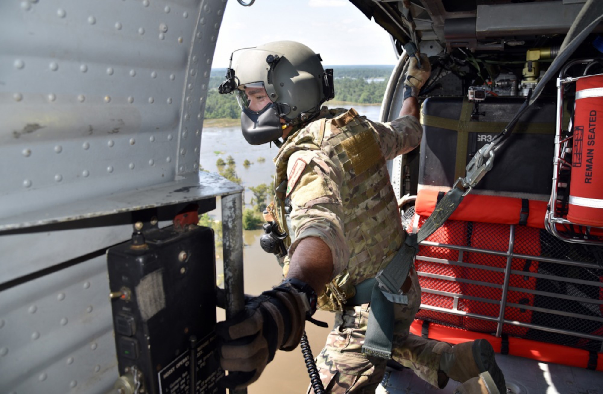 Senior Airman Davy Brinkmann, 920th Rescue Wing, Patrick Air Force Base, Florida, special missions aviations specialist, gets sight on a fellow pararescuemen below as they prepare to hoist two stranded victims of Hurricane Harvey Aug. 31, 2017 from Beaumont, Texas. The 920th RQW deployed roughly 90 Citizen Airmen, three Pave Hawks and two HC-130Ns in support of Air Force Northern’s search and rescue mission for FEMA disaster relief efforts. (U.S. Air Force photo/Tech. Sgt. Lindsey Maurice)