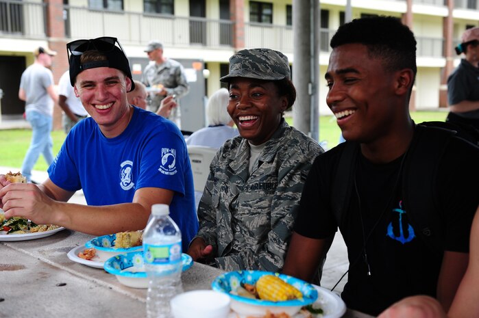 Airman Cameron Flores, left, 437th Aircraft Maintenance Squadron Aircraft Electrical and Environmental Systems specialist, Airman 1st Class Breanna Dennis, center, 437th AMXS crew chief, and Airman 1st Class Corey Wiggins, right, 437th AMXS ELEN specialist, have a conversation while attending a dorm dinner for dormitory residents hosted by the First Sergeants Council and Joint Base Charleston Chaplains Office in the courtyard outside the dorms Aug. 30, 2017.