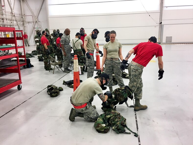 Senior Airman Danielle Monroe (center), emergency management journeyman in the 419th Civil Engineer Squadron, guides Airmen through the survival gear removal process