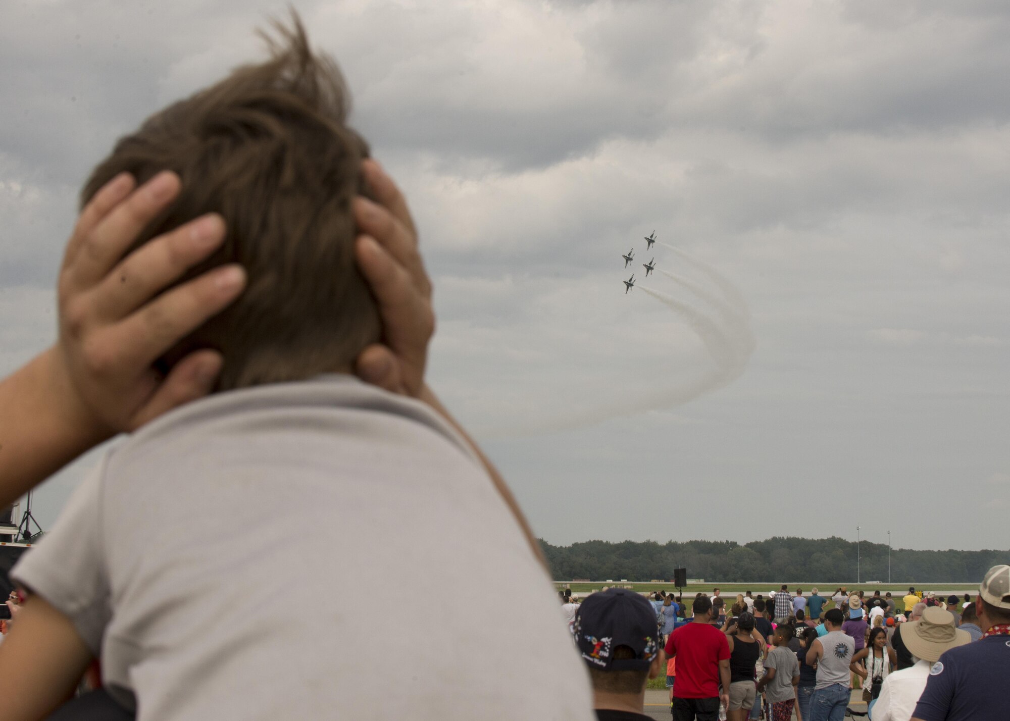 A Team Dover guest watches the U.S. Air Force Thunderbirds during the 2017 Thunder Over Dover Open House Aug. 27, 2017, on Dover Air Force Base, Del . The Thunderbirds have performed for millions of fans since 1953, and are scheduled to complete nearly 70 performances this year. (U.S. Air Force photo by Staff Sgt. Jared Duhon)