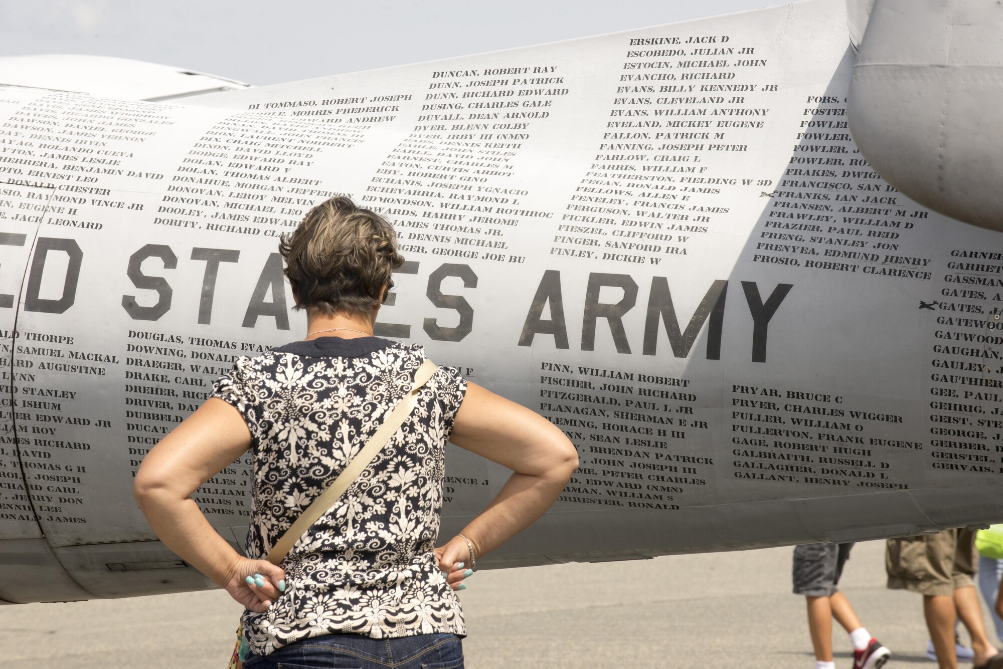 A Team Dover guest reads the names of Vietnam War Prisoners of War and Missing in Action individuals on the “Flying POW/MIA” monument, Grumman OV-1 Mohawk, during the 2017 Thunder Over Dover Open House Aug. 27, 2017, on Dover Air Force Base, Del. The aircraft displays the names of 1,636 soldiers who remain unaccounted for from the Vietnam War. (U.S. Air Force photo by Staff Sgt. Jared Duhon)