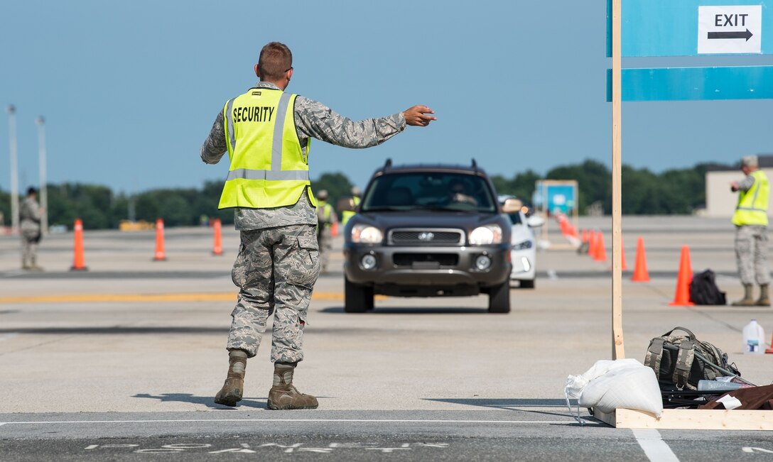 A "Thunder Over Dover" volunteer directs incoming traffic from the North Gate to parking on the flight line Aug. 27, 2017, on Dover Air Force Base, Del. This year’s Open House showcased the capabilities of our Air Force aviation team and celebrated our longstanding relationship with our neighbors in the local Dover community. (U.S. Air Force photo by Roland Balik)