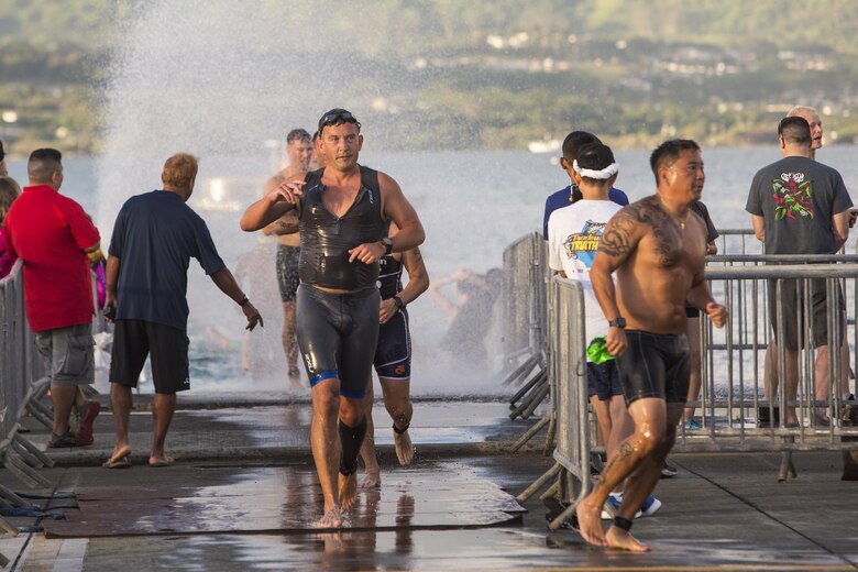 Race participants finish the swim portion of the Tradewind Triathlon at the flight line aboard Marine Corps Air Station (MCAS) Kaneohe Bay, Aug. 27, 2017. The Tradewind Triathlon involves a 500 meter swim in Kaneohe Bay, a 13 mile bike ride on the MCAS Kaneohe Bay flight line, and a 3 mile run around the base. The event is part of the Commanding Officer Race Series and is open for the public to participate in. (U.S. Marine Corps photo by Lance Cpl. Isabelo Tabanguil)
