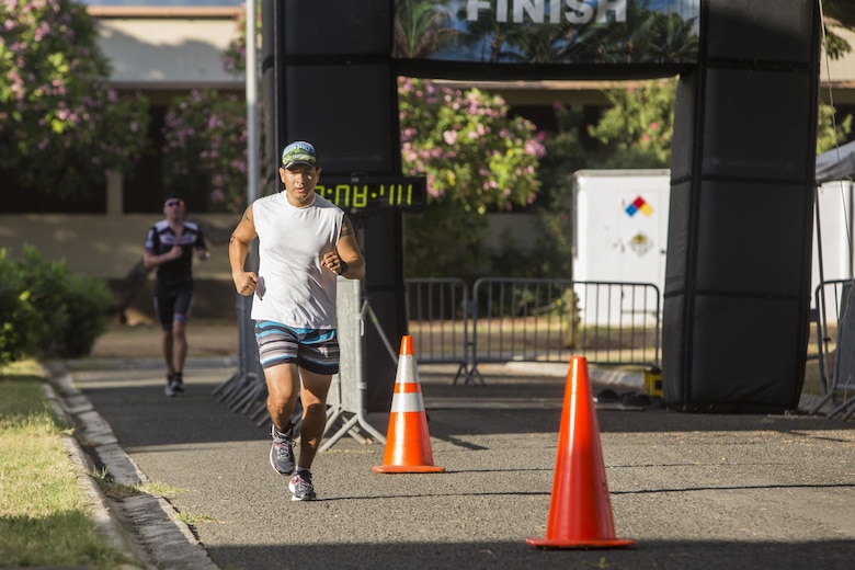 Race participants reach the halfway point during the run portion of the Tradewind Triathlon at Dewey Square, Marine Corps Base Hawaii, Aug. 27, 2017. The Tradewind Triathlon involves a 500 meter swim in Kaneohe Bay, a 13 mile bike ride on the Marine Corps Air Station Kaneohe Bay flight line, and a 3 mile run around the base. The event is part of the Commanding Officer Race Series and is open for the public to participate in. (U.S. Marine Corps photo by Lance Cpl. Isabelo Tabanguil)