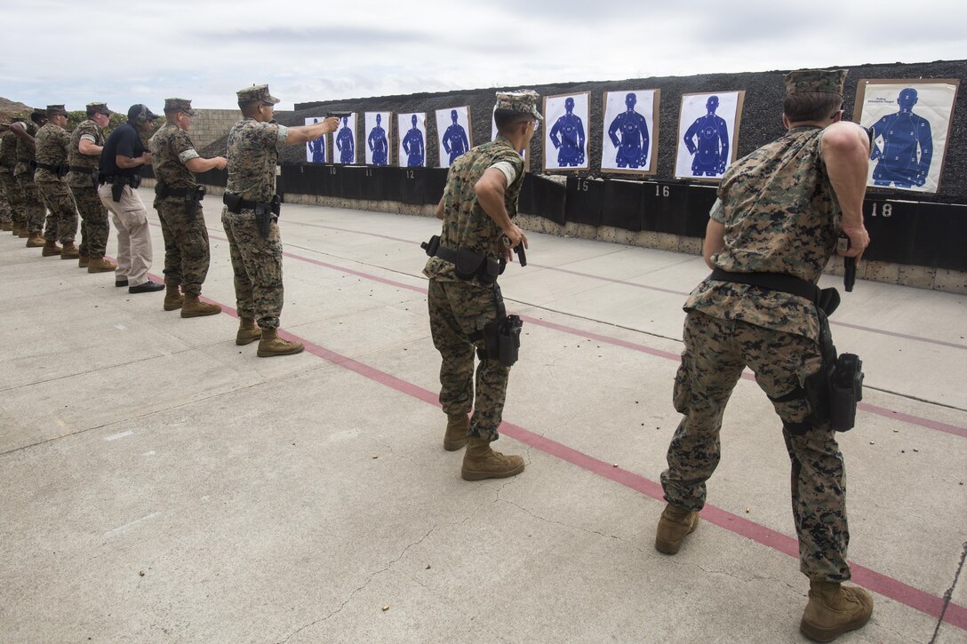 Military police officers with the Provost Marshal’s Office engage targets during an annual pistol and shotgun qualification at Range 6 aboard Marine Corps Base Hawaii, Aug. 29, 2017. The qualification involves engaging targets with a Beretta M9 service pistol at close range, moving from cover to cover, and firing a shotgun while closing distance with the targets. (U.S. Marine Corps photo by Lance Cpl. Isabelo Tabanguil)