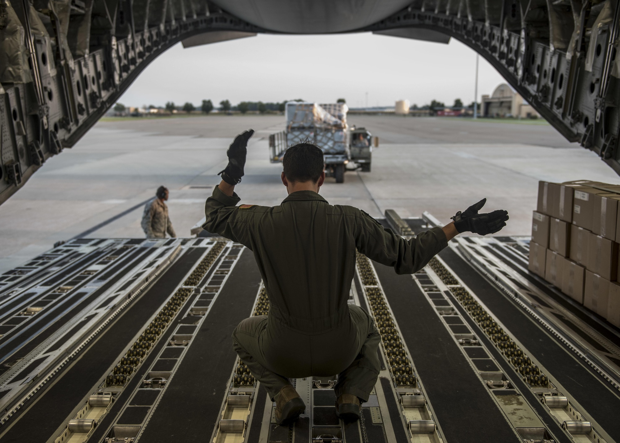 A loadmaster with the 6th Airlift Squadron directs 375th Logistics Readiness Squadron personnel toward a C-17 Globemaster III, which will transport cargo and 375th Aeromedical Evacuation Squadron personnel to Little Rock Air Force Base, Ark. to provide medical relief after Hurricane Harvey caused catastrophic floods in the states of Texas and Louisiana, Scott Air Force Base, Ill., Aug. 30, 2017.  The 375th LRS loaded 6.5 tons of medical supplies onto a C-17 Globemaster III for the nine-person medical team. The 375th AES crew, prepared to provide relief for 30 days, will be staged at Little Rock Air Force Base, where they will pick up high-priority patients from George Bush Intercontinental Airport and transport them to one of seven hospital locations across the states of Texas, Oklahoma, Louisiana, Tennessee, Mississippi, and Alabama.   (U.S. Air Force photo by Tech. Sgt. Jodi Martinez)