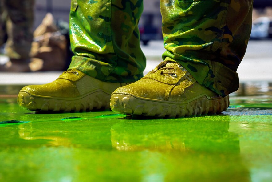 Chief Master Sgt. Brandon Broughman, 347th Rescue Group superintendent, stands in a puddle of sea dye he was drenched in after his final flight, Aug. 17, 2017, at Moody Air Force Base, Ga. Broughman concluded his 30-year career as a loadmaster on Sept. 1. During his tenure, he dedicated service to more than 5 variants of C-130’s in air mobility and tactical airlift support. (U.S. Air Force photo by Senior Airman Greg Nash)