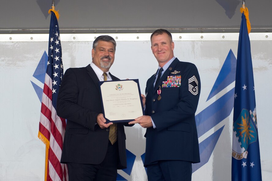 Retired Brigadier Gen. Gregory Otey presents Chief Master Sgt. Brandon Broughman, 347th Rescue Group superintendent, with a retirement certificate during Broughman’s retirement ceremony, Sept. 1, 2017, at Moody Air Force Base, Ga. Broughman concluded his 30-year career as a loadmaster. During his tenure, he dedicated service to more than 5 variants of C-130’s in air mobility and tactical air drop support. (U.S. Air Force photo by Senior Airman Greg Nash)
