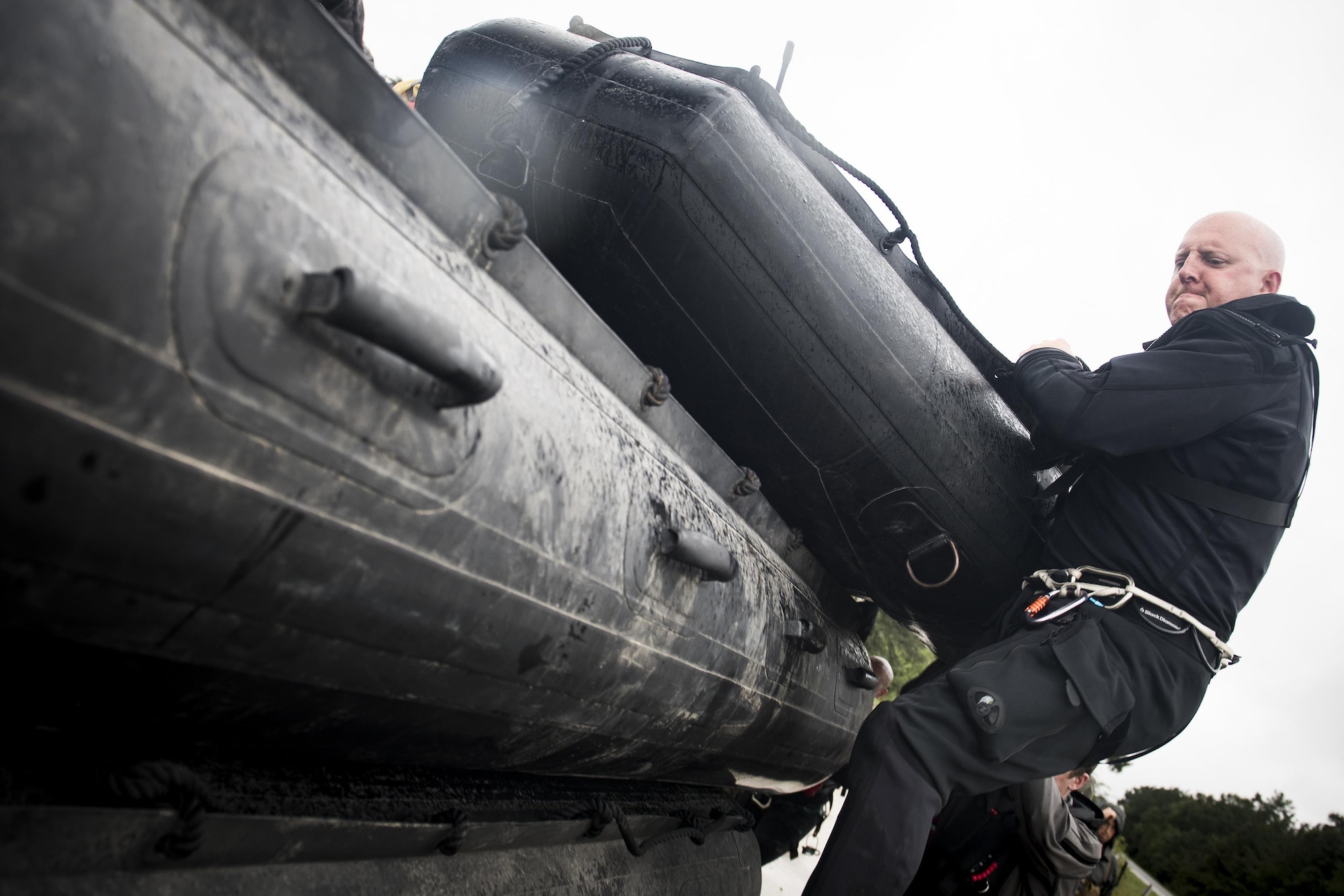 A pararescueman from the 58th Rescue Squadron pushes a stack of rescue boats onto a transport vehicle prior to a rescue mission, Aug. 30, 2017, at the Orange County Convention and Expo Center in Orange, Texas.