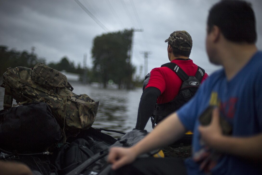 A pararescueman from the 58th Rescue Squadron pulls a boat carrying victims of Hurricane Harvey, Aug. 30, 2017, in Orange, Texas.