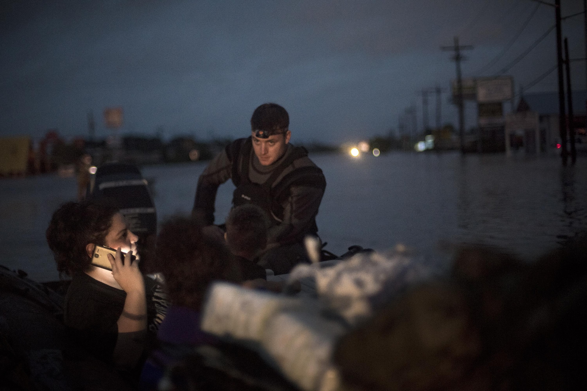 A pararescueman from the 58th Rescue Squadron sits in a rescue boat with a family that was displaced by floodwaters, Aug. 30, 2017, in Orange, Texas.