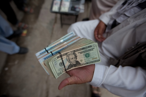 Widespread corruption has permeated the highest levels of the Government of the Islamic Republic of Afghanistan.  Money changer displaying his wares.
