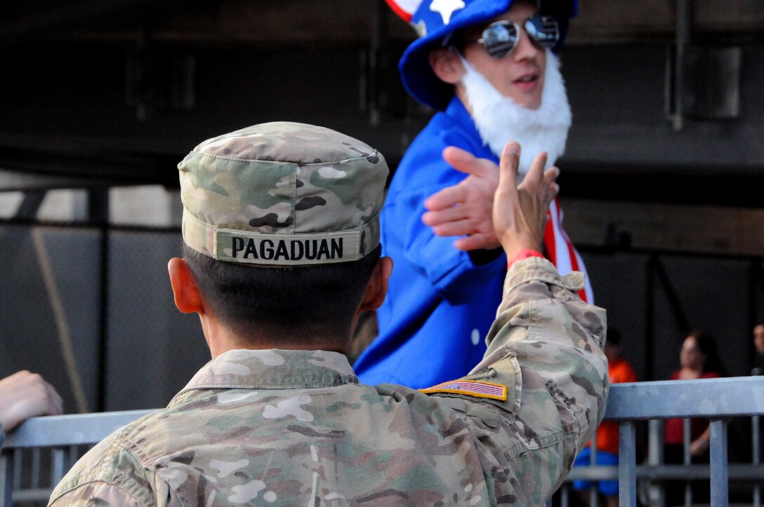 Staff Sgt. Michael Pagaduan, assigned to the Army’s 404th Civil Affairs Battalion, gets a high-five Sept. 1 from ‘Uncle Sam’ prior to a military appreciation game with the United States men's national soccer team at Red Bull Arena in Harrison, New Jersey.  Service members from the Army and Air Force held the U.S. flag for the national anthem.