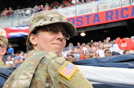 Master Sgt. Chanda Caro, assigned to the U.S. Army Reserve’s 99th Regional Support Command, headquartered at Joint Base McGuire-Dix-Lakehurst, New Jersey, helps hold the flag Sept. 1 prior to the start of a United States men's national soccer team game at Red Bull Arena in Harrison, New Jersey.  Service members from the Army and Air Force held the U.S. flag for the national anthem.