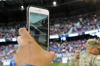 A Soldier takes video Sept. 1 prior to helping unveil the U.S. flag for the national anthem at Red Bull Arena in Harrison, New Jersey.   Service members from the Army and Air Force held the flag for the national anthem.