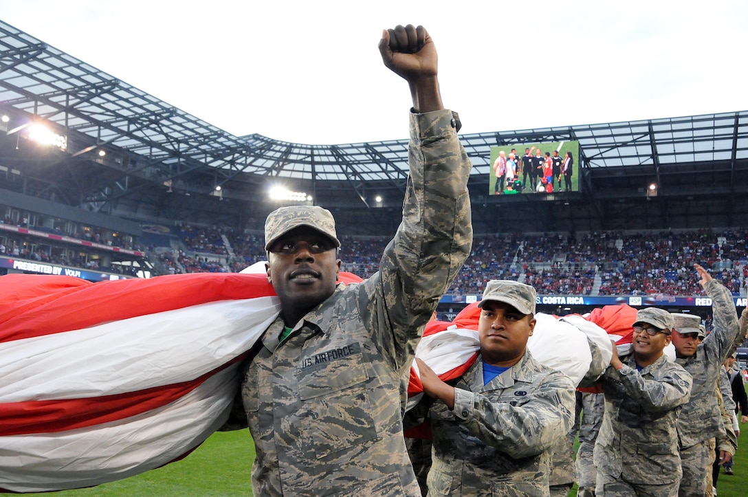 Airmen 1st Class Ezell Jones Jr., assigned to the U.S. Air Force’s 305th Maintenance Squadron, reacts to the crowd Sept. 1 after helping to hold the U.S. flag for the national anthem.  The service members were there to hold the flag for the national anthem as part of a military appreciation theme for the game.