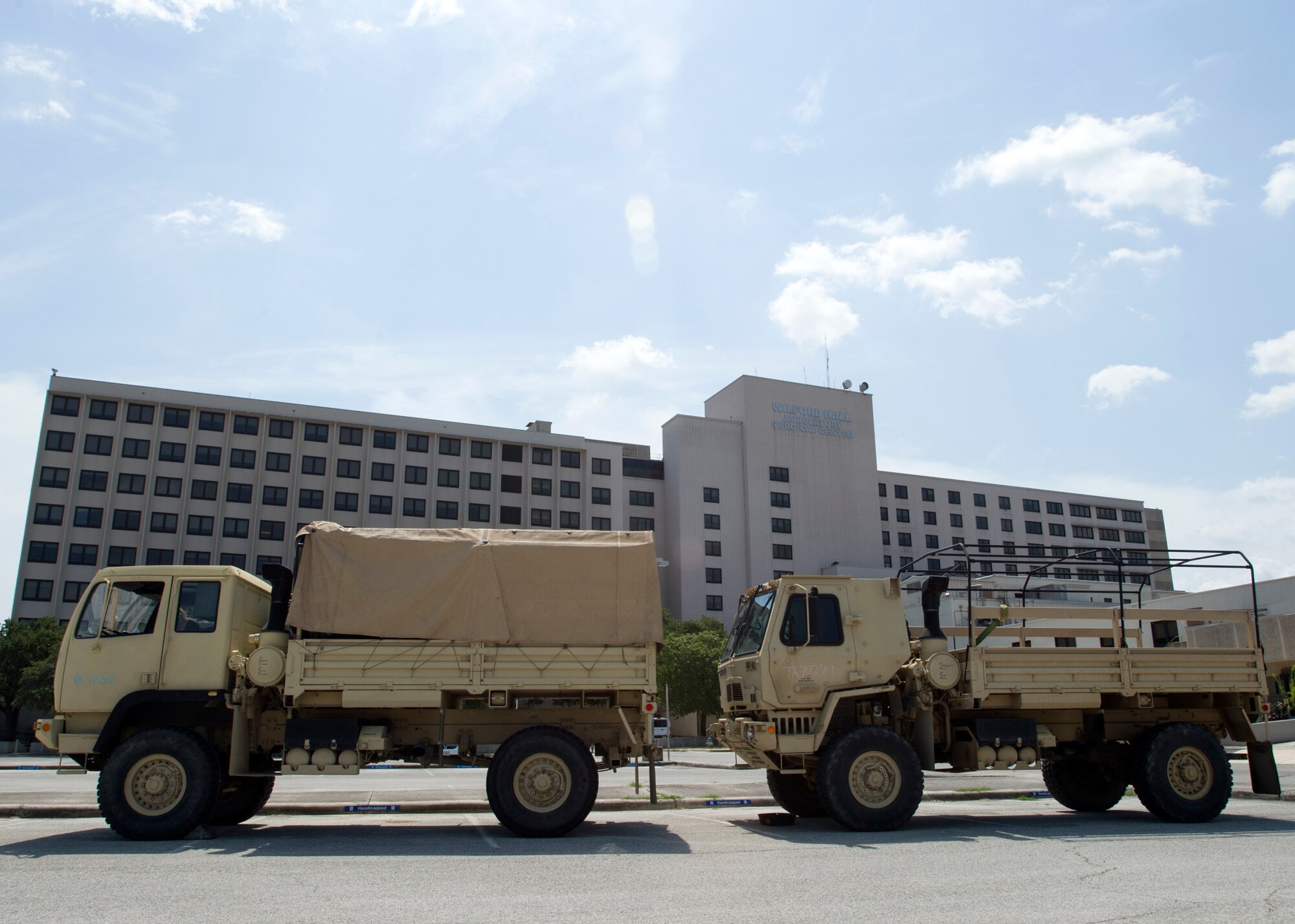 Two light medium tactical vehicle is parked outside of the old Wilford Hall Ambulatory Surgical Center Sept. 2 after dropping off 67 soldiers, on Joint Base San Antonio-Lackland, Texas. More than 500 soldiers are awaiting future deployment instructions at the old Wilford Hall in response to the devastation caused by Hurricane Harvey. (U.S. Air Force photo/Staff Sgt. Kevin Iinuma)