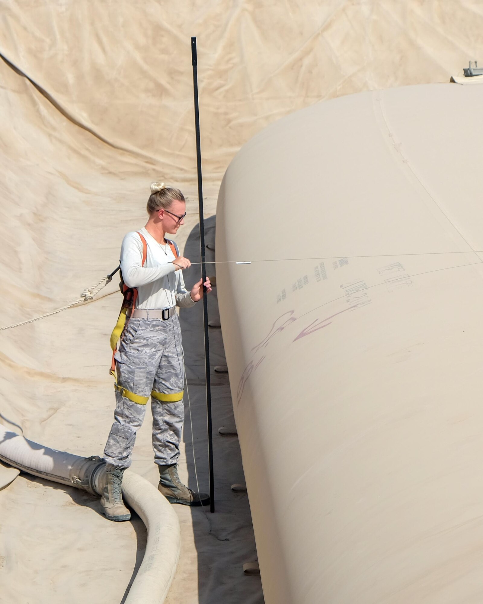 Senior Airman Megan Frei, 380th Expeditionary Logistics Readiness Squadron fuels management technician, measures a fuel bladder Aug. 4, 2017, at Al Dhafra Air Base, United Arab Emirates.
