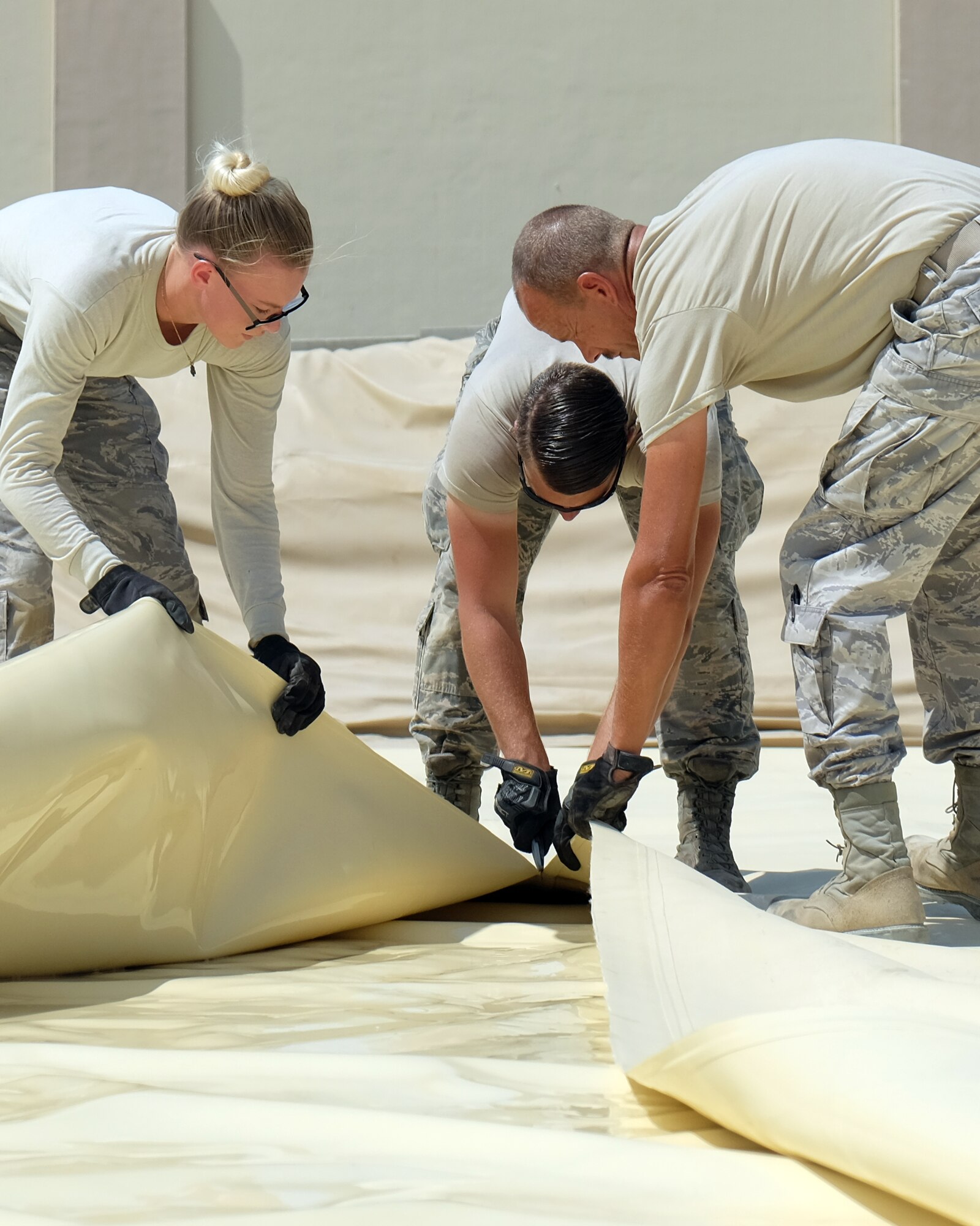 380th Expeditionary Logistics Readiness Squadron fuels management Airmen cut open a fuel bladder Aug. 4, 2017, at Al Dhafra Air Base, United Arab Emirates.