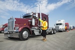 Worker on ground directing semi trailer