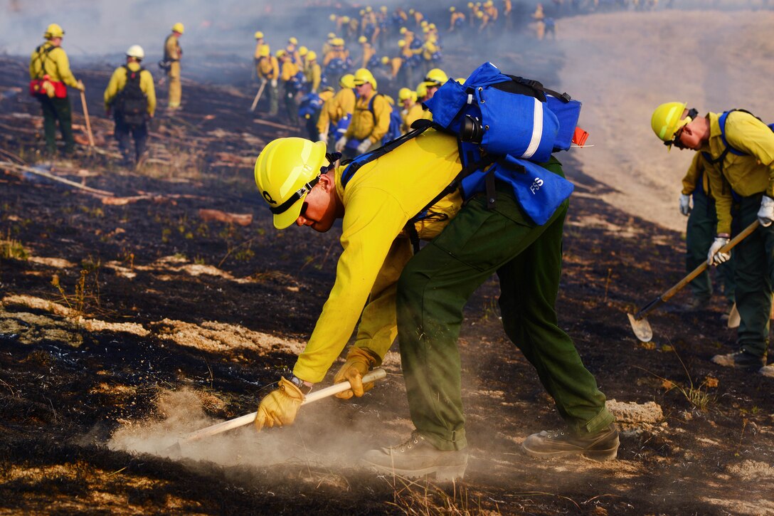 Oregon Army National Guard Pfc. Solomon Quijano checks for hot spots during a firefighting training