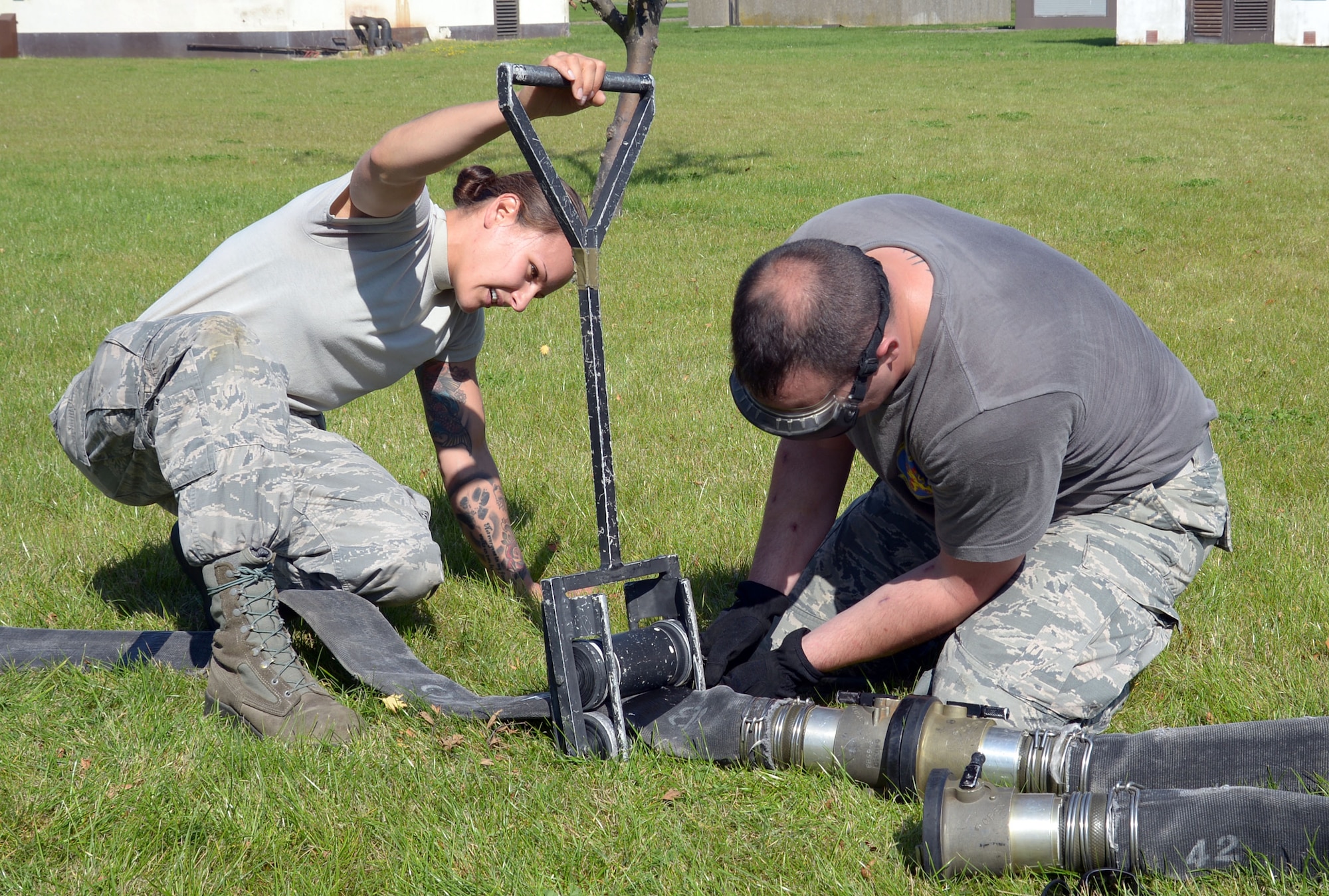 Airmen attach squeegee to hose