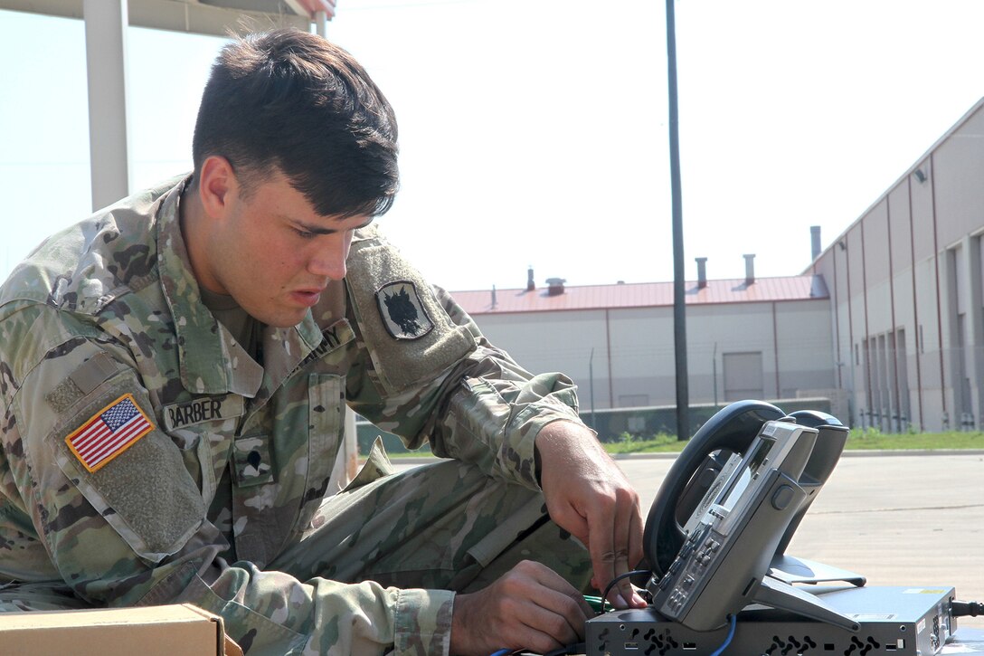 A soldier works on a communications system.