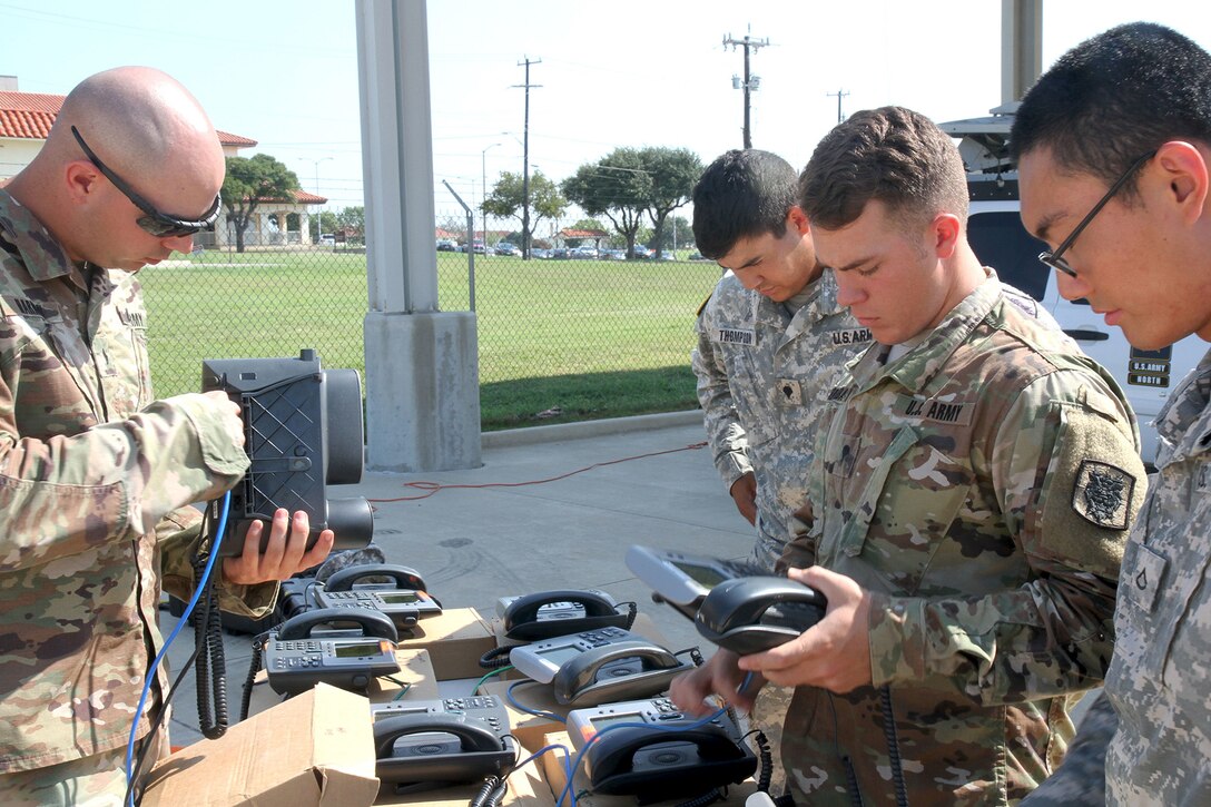 Soldiers prepare communication devices for emergency use.